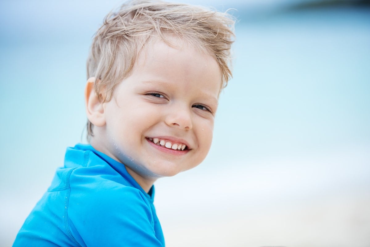 smiling-little-boy-on-the-beach-PKESYV2-min